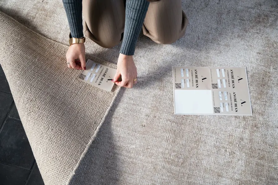 Handen kiezen kleuren bij een tapijt. Tapijt van Ancré rugs.