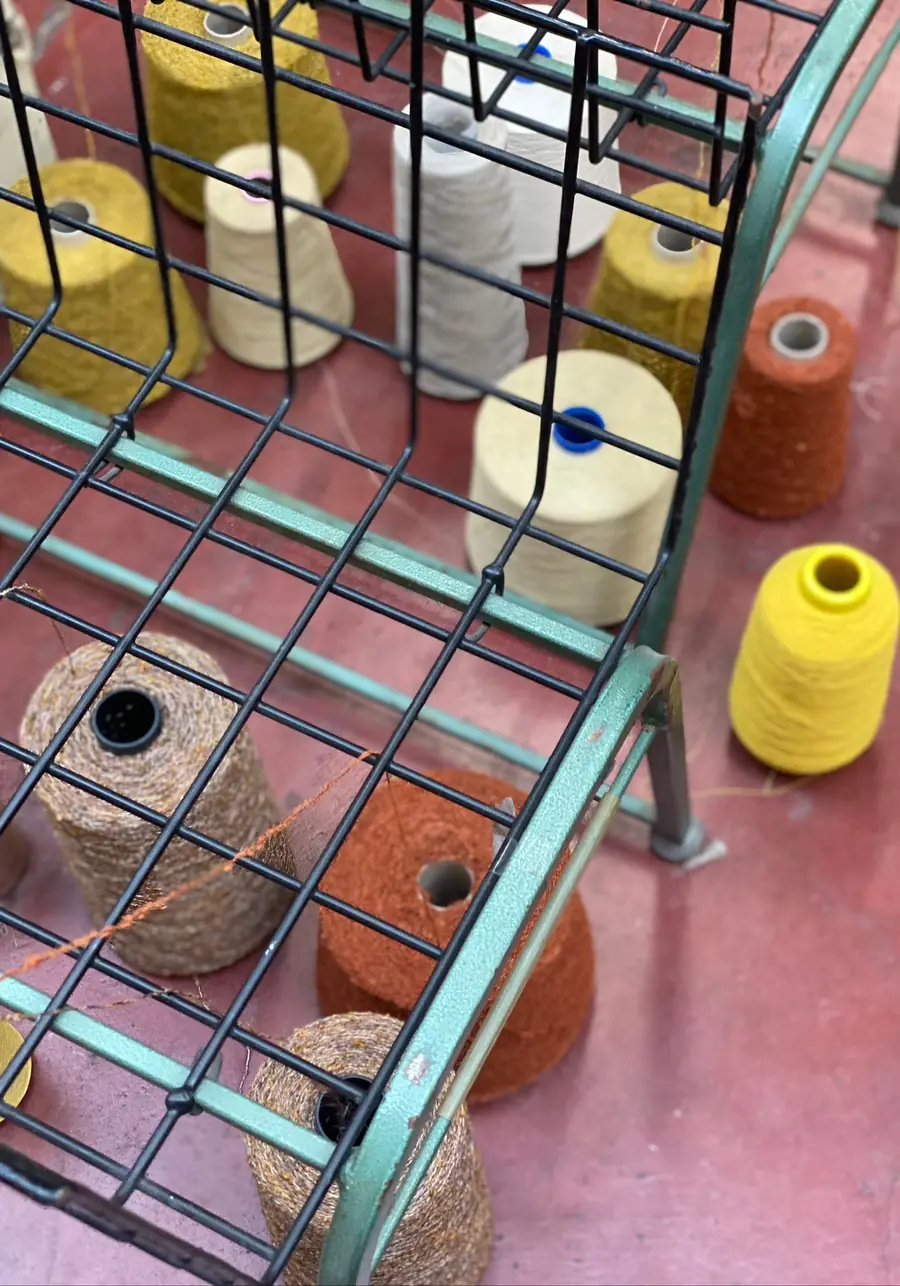 Garenkonen op een rek in het atelier. Tapijt van Cobbaert Delphine.