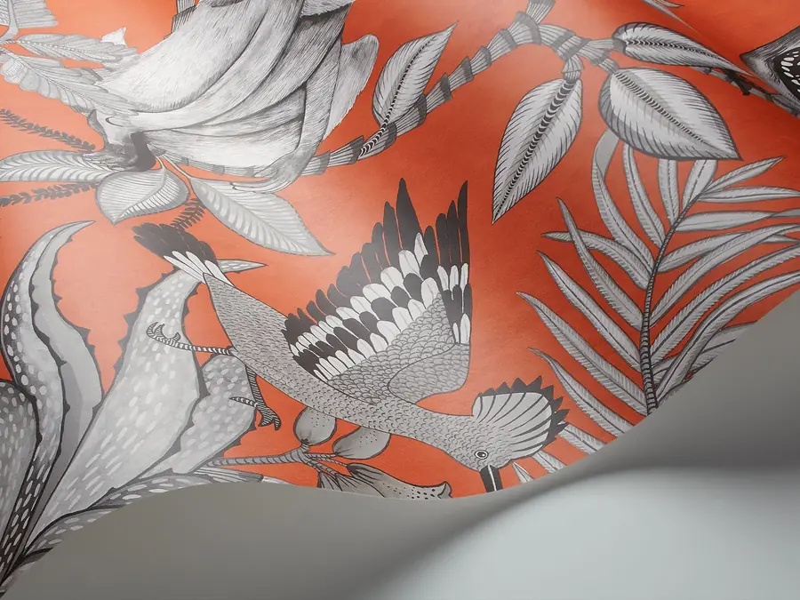 Omgekrulde behangbaan met oranje vogeldessin. Behang van Cole & Son.