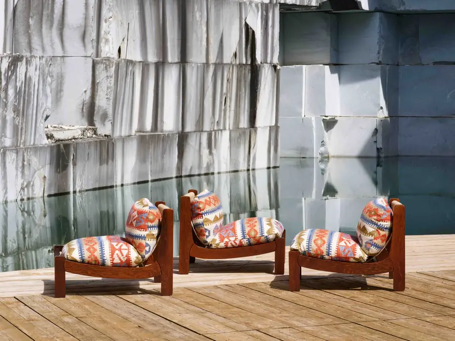 Twee fauteuils in bedrukte stof tussen de marmerblokken van Carrara. Stoffen van Decortex Firenze.