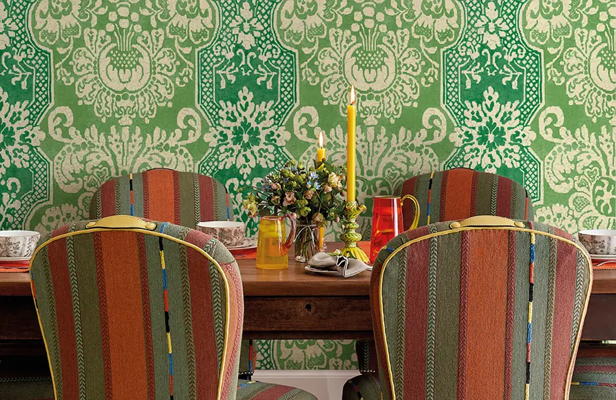 Eetkamer met groen damastbehang en gestreepte stoelen. Stoffen van GP & J Baker.