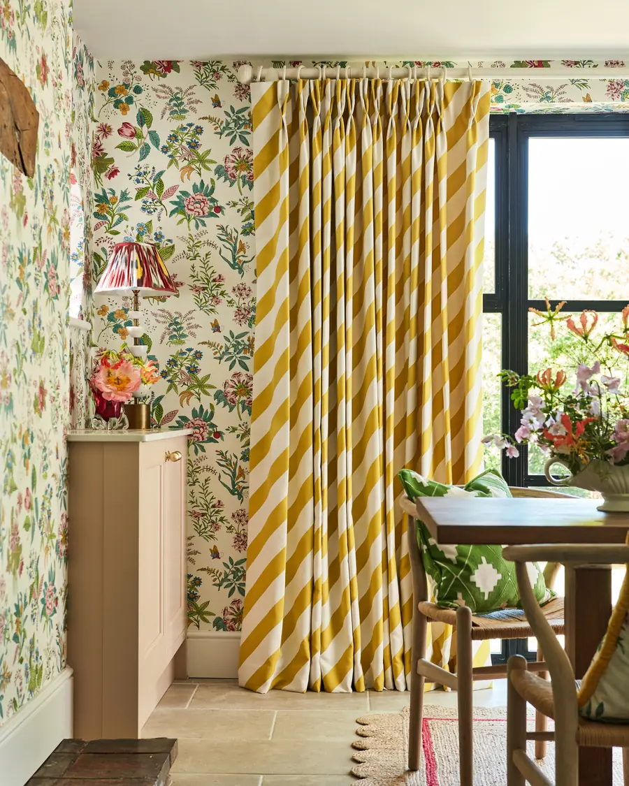 Eetkamer met gele chevrongordijnen en bloemenbehang. Stoffen van Harlequin.