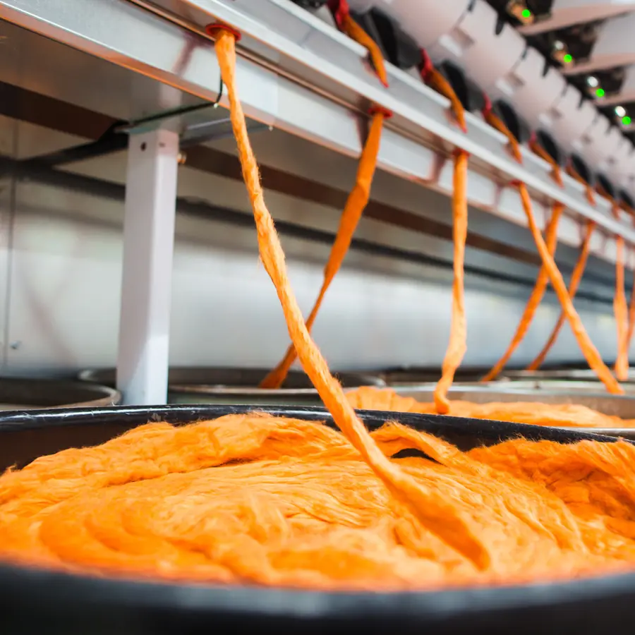 Oranje voorgaren op de spinmachine in de molen. Stoffen van Ian Mankin.