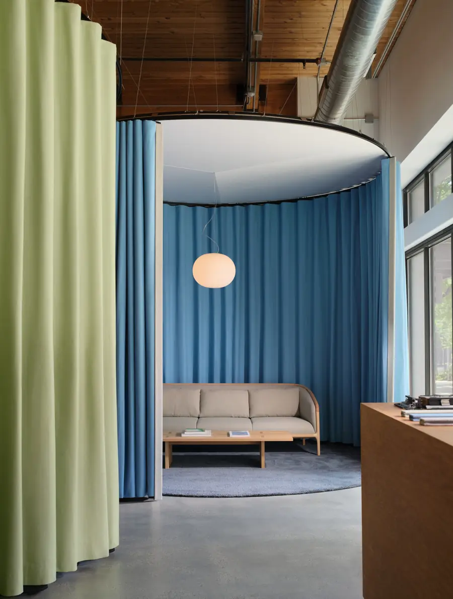 Groene en blauwe gordijnen als ronde kamerscheiding. Stoffen van Kvadrat.