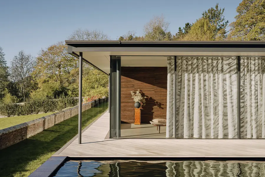 Paviljoen aan het water met linnen gordijnen. Stoffen van Larsen.