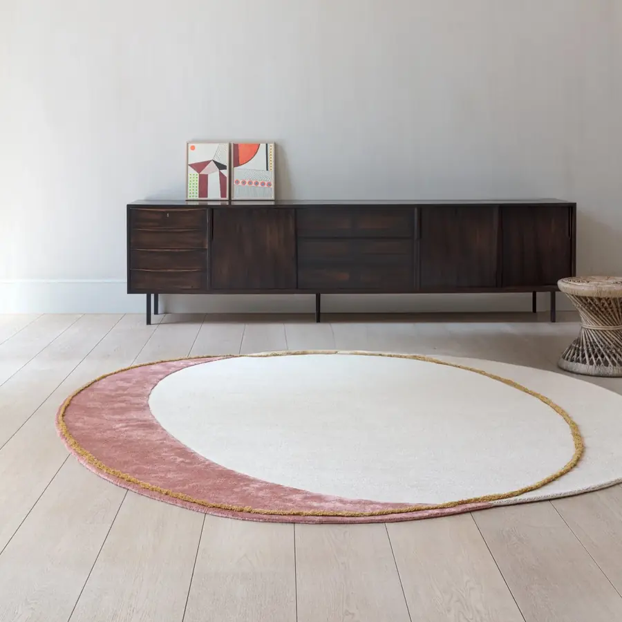 Rond roze tapijt bij een dressoir. Tapijt van Ligne Pure.