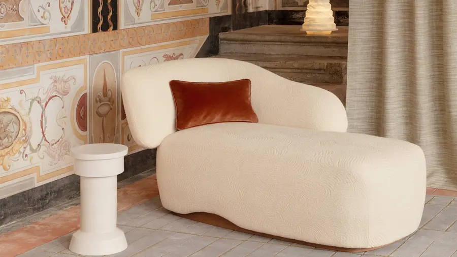 Witte chaise longue met roestkleurig kussen voor fresco. Stoffen van Misia.