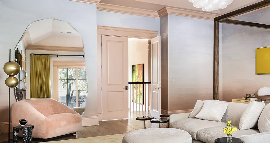 Zitkamer met zilvergrijze wandbekleding en roze fauteuil. Behang van Phillip Jeffries.