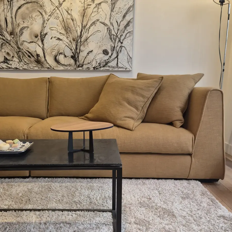 Sofa met kussens onder een schilderij. Stoffen van Pure and Present.